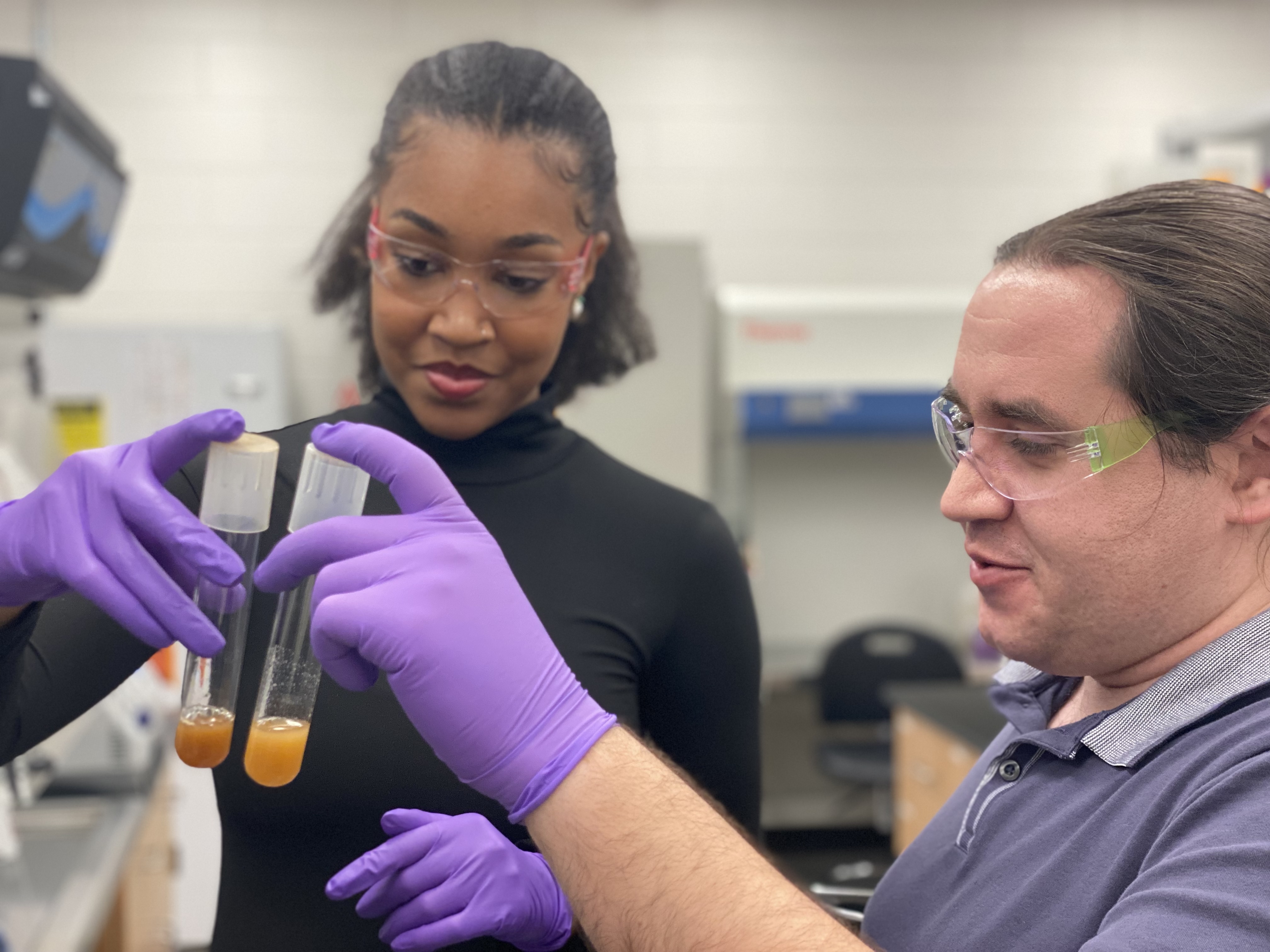 Biology Ph.D. student Autumn Peterson, the study's lead author, looks at yeast cells with Research Scientist Anthony Burnetti, the study's corresponding author, in the lab. (Photo: Audra Davidson)