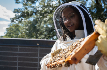 Georgia Tech's Janelle Dunlap conducts a hive inspection at the The Kendeda Building for Innovative Sustainable Design. 
